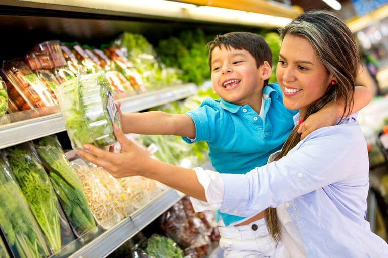 Woman at the supermarket with her son buying groceries